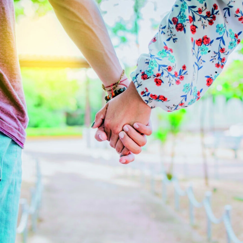 Close up of couple holding hands outdoors, Close up of young couple walking holding hands. Close-up of teenagers holding hands in a park. View of young couple holding hands outdoors Close up of couple holding hands outdoors, Close up of young couple walking holding hands. Close-up of teenagers holding hands in a park. View of young couple holding hands outdoors