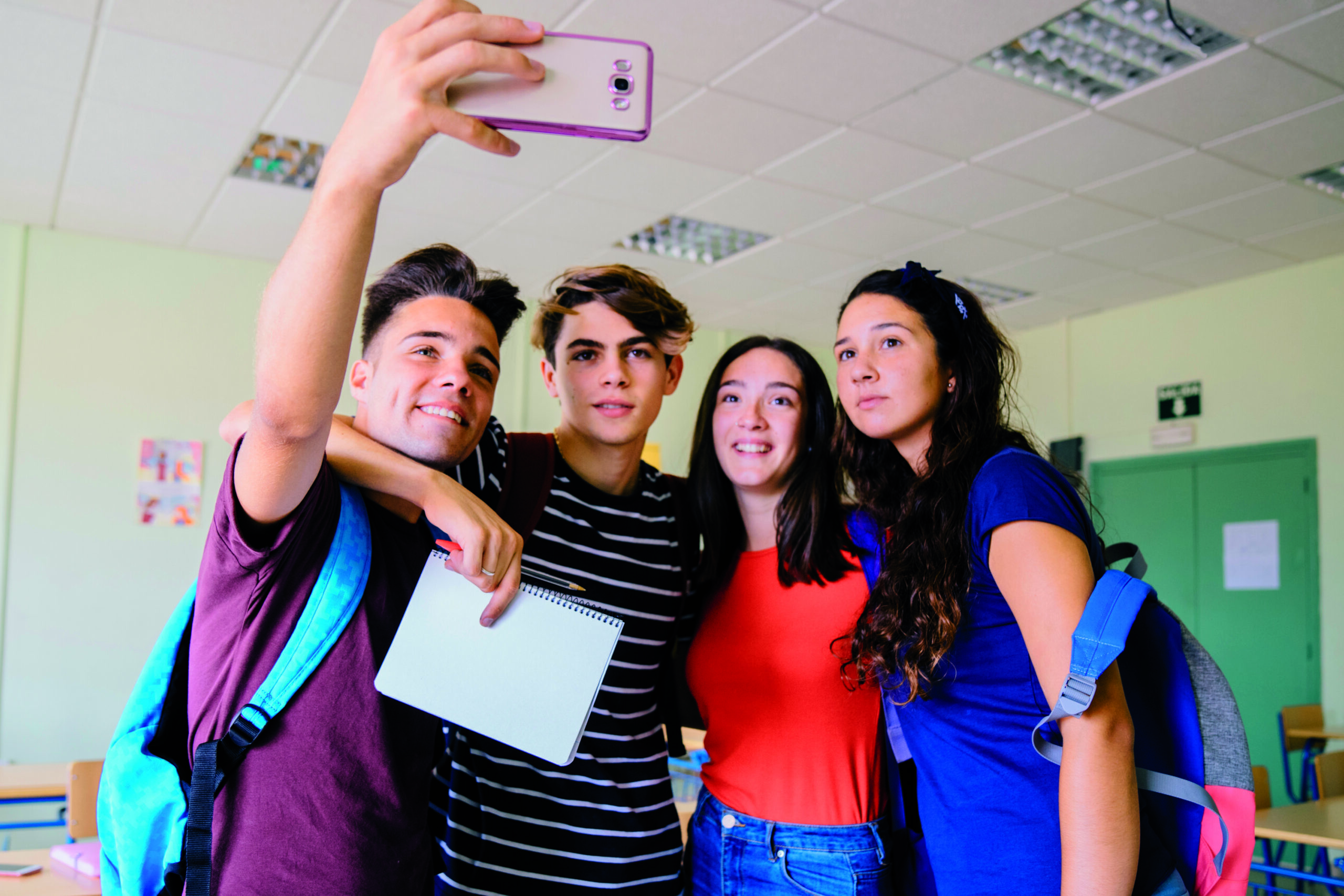 group schoolkids taking selfie classroom